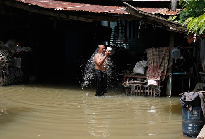 Tắm bằng nước lũ bẩn thỉu ở Ayutthaya, Thái Lan.
